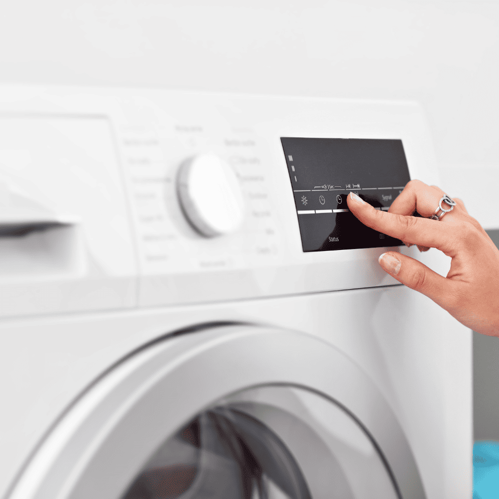 Female Hand Pressing Button on Washing Machine