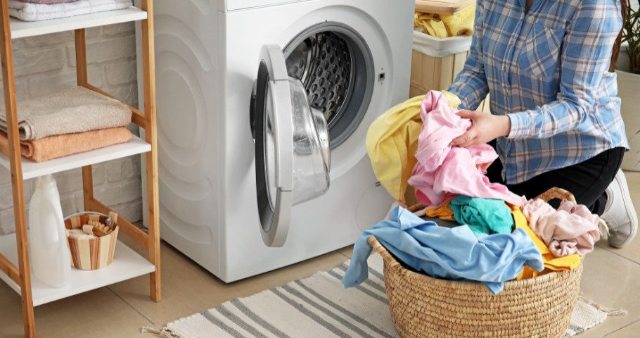 Woman loading the washing machine with laundry