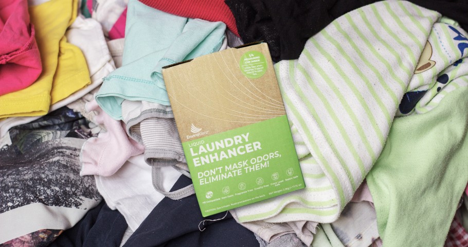 EnviroKlenz Liquid Laundry Enhancer laying on a pile of dirty clothes